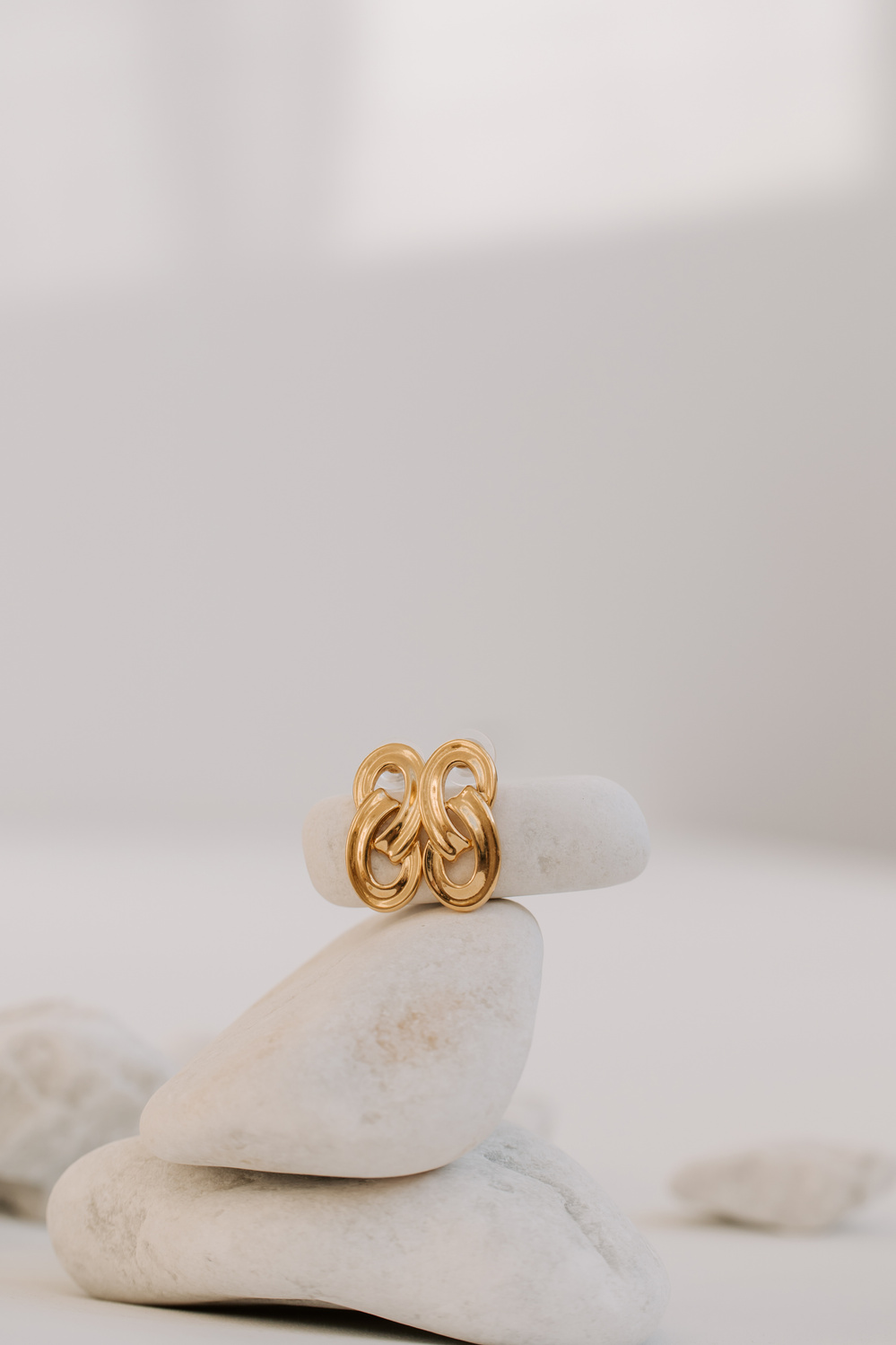 Pair of Gold Earrings on Stack of Rocks